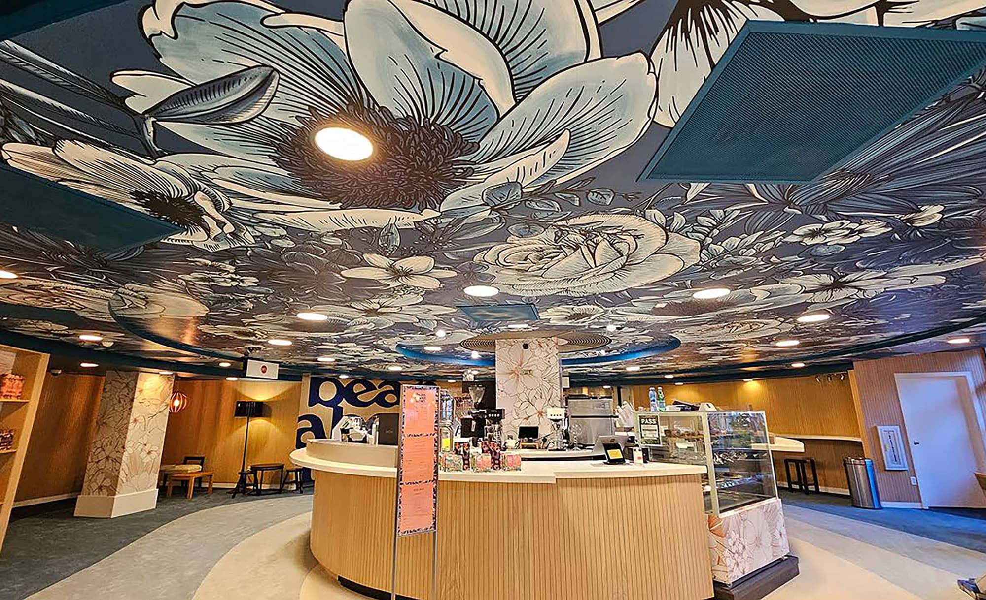 DFS Waikiki reopening eye-catching ceiling graphics over contour ceiling above cafe with vinyl wrapped columns food fridge and shelf inserts